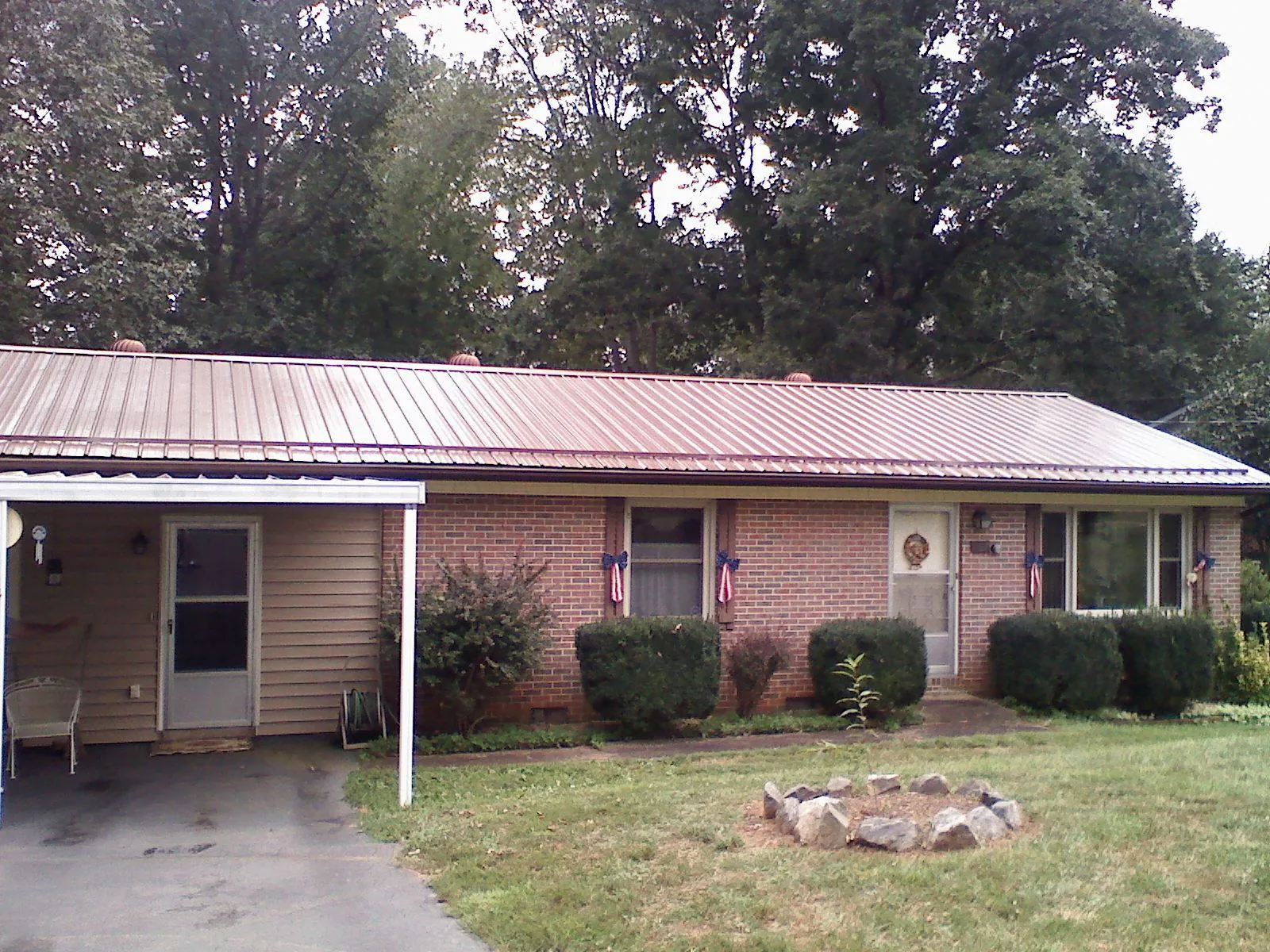 Bronze metal roof and carport on a brick ranch home — Roof Repair work by our crew in Eureka